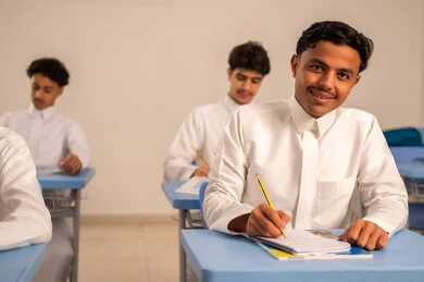 المشاركة الفعالة للطلاب، ايماءات التمعن والتركيز، أهداف التربية والتعليم، مجموعة من الطلاب العربيون الخليجيون السعوديون يرتدي الثوب الابيض يقومون بحل اسئلة الدرس، التعليم في المملكة العربيه السعودية