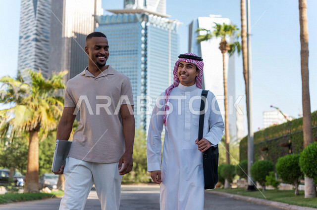 شابان عربيان خليجيان سعوديان يقومان بجولة داخل المدينة المالية ، الاستجمام و التنزه في الهواء الطلق ، لقاء و تعارف ، مقابلة أصدقاء ، قضاء وقت ممتع في مدينة الملك عبد الله المالية ( كافد ) في مدينة الرياض ، المملكة العربية السعودية