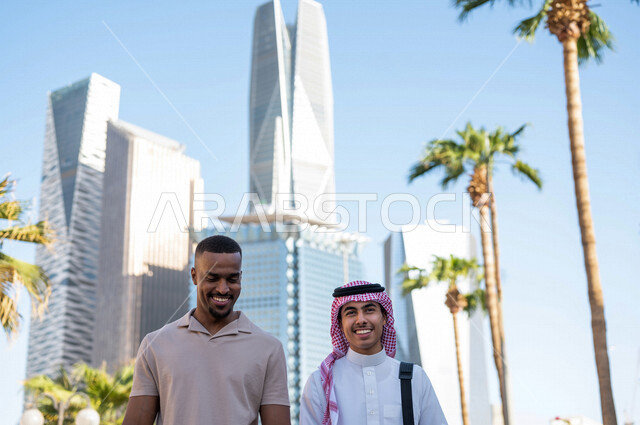 Two Saudi Arabian Gulf youths taking a tour inside the financial city, recreation and hiking in the fresh air, meeting and acquaintance, meeting friends, spending quality time in King Abdullah Financial City (KAFED) in the city of Riyadh, Kingdom of Saudi