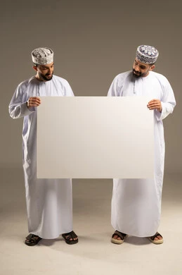 Using a whiteboard for ease of explanation, clarifying the procedures followed, a portrait of two Omani Gulf Arab men wearing dishdashas and kumas and holding a blank whiteboard, gray background