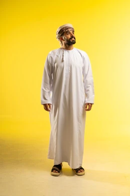 Looking far away at something, elegance and attention to appearance, the concept of masculinity and strength, a portrait of an Arab Gulf Omani man wearing a dishdasha and a turban, showing gestures of happiness, expressions of self-confidence, with a yellow background.