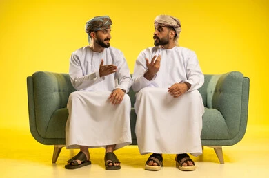 مناقشة الأخبار و التحدث مع الأصدقاء، جلسة وناسة و تعارف، بورتريه لرجلين عربيين خليجيين عمانيين يرتديان الدشداشة و العمامة يجلسان على أريكة مريحة و يتبادلان أطراف الحديث, إيماءات وجه و يدين تدل على التفاعل, خلفية صفراء مناقشة الأخبار و التحدث مع الأصدقاء، جلسة وناسة و تعارف، بورتريه لرجلين عربيين خليجيين عمانيين يرتديان الدشداشة و العمامة يجلسان على أريكة مريحة و يتبادلان أطراف الحديث, إيماءات وجه و يدين تدل على التفاعل, خلفية صفراء