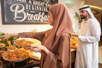 السعادة والاستمتاع خارج المنزل، المأكولات والمخبوزات الشهية والطازجة ،اطباق متنوعه ومختلفه ،اختيار طبق الفطور من البوفيه المفتوح، قضاء اوقات ممتعه في عطلة نهاية الاسبوع, زوجان عربيان اماراتيان يرتديان الزي التقليدي الاماراتي يحملان اطباق الطعام السعادة والاستمتاع خارج المنزل، المأكولات والمخبوزات الشهية والطازجة ،اطباق متنوعه ومختلفه ،اختيار طبق الفطور من البوفيه المفتوح، قضاء اوقات ممتعه في عطلة نهاية الاسبوع, زوجان عربيان اماراتيان يرتديان الزي التقليدي الاماراتي يحملان اطباق الطعام