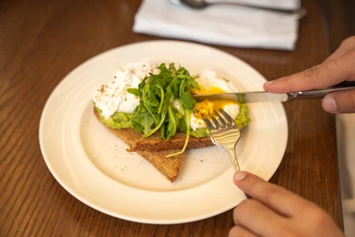 طبق مفيد وصحي وسريع، اتباع الحميات الغذائية، أطعمة ووجبات لذيذة مليئة بالبروتينات الصحية، وجبة فطور صباحية، صورة لطبق يحتوي قطعتين توست مغطاة بزبدة الأفوكادو وجبنة الفيتا مزينة بأعشاب الجرجير الطازجة