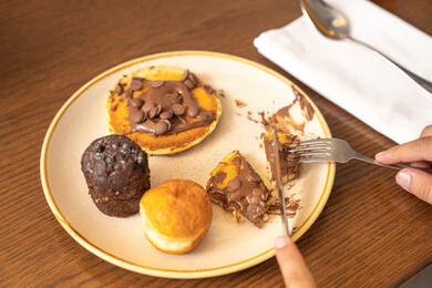 مأكولات غنية بالسكريات والسعرات الحرارية، معجنات طازجة مخبوزة في الفرن، صورة مقربة لطبق من الكاب كيك والبان كيك الشهي المزين بالشوكولاتة، أطعمة وحلويات لذيذة