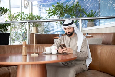 إيماءات الاندماج والتركيز، التسوق الالكتروني وتصفح برامج وتطبيقات الجوال، رجل عربي خليجي اماراتي يرتدي الكندورة والغترة يجلس فى احد المقاهي يحمل الهاتف المحمول، تطور التكنولوجيا والأجهزة التقنية، الدردشة مع الأهل والأصدقاء إيماءات الاندماج والتركيز، التسوق الالكتروني وتصفح برامج وتطبيقات الجوال، رجل عربي خليجي اماراتي يرتدي الكندورة والغترة يجلس فى احد المقاهي يحمل الهاتف المحمول، تطور التكنولوجيا والأجهزة التقنية، الدردشة مع الأهل والأصدقاء