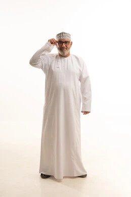 مفهوم طول النظر وقصره، الشعور بالسعادة والفرح بوضوح الرؤية, استخدام النظارة الطبية لتصحيح البصر, بورتريه لرجل عربي خليجي عماني يرتدي الدشداشه والكمه يمسك نظارته بيديه بايماءات استخدام الوسائل المساعده على النظر باستخدام النظارات الزجاجيه الطبيه، خلفيه بيضاء