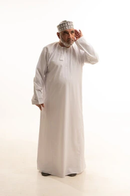 ايماءات وجه ويدين تدل على السعادة والسرور، إيماءات السعادة بسماع أخبار جيدة، وضع اليد خلف الاذن لرصد الصوت القادم، بورتريه لرجل عربي خليجي عماني يرتدي الدشداشه والعمامة يضع يده وراء اذنه لمحاولة السمع، الجسم بالطول الكامل، خلفية بيضاء