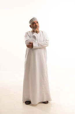 Confusion and inability to make decisions, facial gestures indicating difficulty in determining the situation, a portrait of an elderly Omani man wearing a dishdasha and kumma showing signs of confusion, thinking, and expressing an opinion, with a white background.