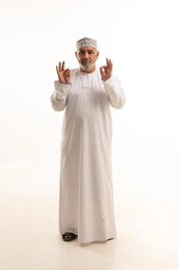 التعبير عن الجودة والاتقان، البشاشة والشعور بالرضا, الموافقة والقبول والنصيحة، بورتريه لرجل عربي خليجي عماني مبتسم يرتدي الدشداشة والكمه يقوم برفع يديه بحركات دائرية بإيماءات الجودة والامتياز والتميز، صورة الجسم بالطول الكامل, خلفية بيضاء