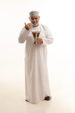 The concept of perfuming with incense, the use of oud wood during holidays and occasions, Arab customs and traditions, a portrait of an elderly Arab Gulf Omani man wearing traditional attire and applying perfume from a incense burner, attention to external appearance and elegance, full-body, white background.