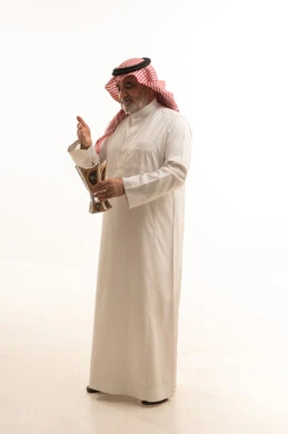 The use of oud wood during holidays and occasions, the concept of perfuming with incense, Saudi customs and traditions, a portrait of an elderly Arab Gulf Saudi man wearing traditional attire and a ghutrah, applying perfume from a incense burner, attention to external appearance and elegance, full-body, white background.