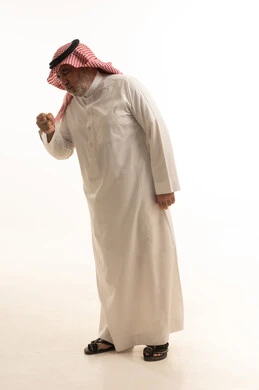 The occurrence of a cold, cough, flu, and sore throat, a portrait of an elderly Arab Gulf Saudi man wearing traditional attire, opening his hands near his mouth while sneezing, feeling chest pain, gestures of illness, fatigue, runny nose, and difficulty breathing, full body length, white background.