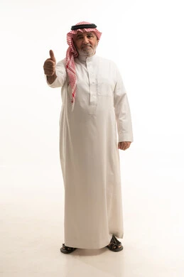 مقابلة شخص ما، بورتريه لرجل مسن عربي خليجي سعودي يرتدي الزي التقليدي يشير بيده بإيماءات مصافحة أحد ما، الطول الكامل للجسم، خلفية بيضاء