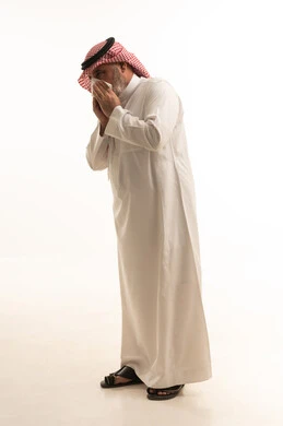 Cough, flu, and sore throat, a portrait of an elderly Arab Gulf Saudi man wearing traditional attire, opening his hands near his mouth while sneezing, suffering from a cold, feeling chest pain, gestures of illness, fatigue, runny nose, and difficulty breathing, full body length, white background.