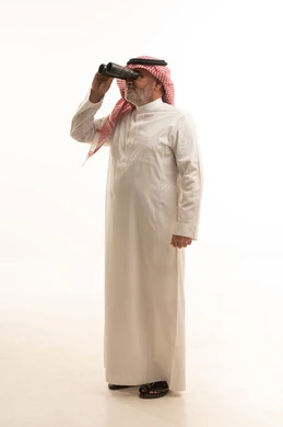 Seeing distant things, elegance and handsomeness, and attention to external appearance, a portrait of an elderly Saudi Arabian Gulf man wearing traditional attire holding a binocular in his hand, full-body, white background.