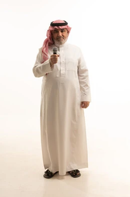 إجراء المقابلات وطرح الأسئلة، التواصل الفعال وتبادل الحوارات والنقاشات، بورتريه لرجل عربي خليجي سعودي كبير السن يرتدي الثوب التقليدي والشماغ يحمل بيده مكبر الصوت يقوم بإلقاء الخطابات، طول الجسم بالكامل، خلفية بيضاء