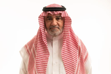 الأناقة والوسامة والاهتمام بالمظهر الخارجي، بورتريه مقرب لرجل عربي خليجي سعودي كبير السن يرتدي الزي التقليدي يقف باستقامة، النظر إلى الكاميرا بإيماءات الجدية والثقة بالنفس، خلفية بيضاء