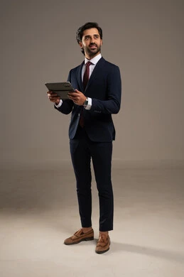 استخدام تقنية حديثة ومتطورة، إدارة شؤون الأعمال وتنظيمها، عقد إجتماع عمل عبر الإنترنت، بورتريه لرجل اعمال عربي خليجي سعودي يرتدي البدلة الرسمية يحمل بيده التابليت المحمول, دمج التكنولوجيا في الحياة العملية، الجسم بالطول الكامل، خلفية بيضاء