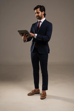 استخدام تقنية حديثة ومتطورة، إدارة شؤون الأعمال وتنظيمها، عقد إجتماع عمل عبر الإنترنت، بورتريه لرجل اعمال عربي خليجي سعودي يرتدي البدلة الرسمية يحمل بيده التابليت المحمول, دمج التكنولوجيا في الحياة العملية، الجسم بالطول الكامل، خلفية بيضاء