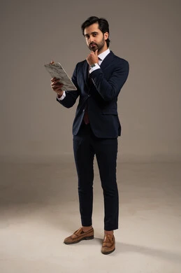 Preparing work-related reports, checking the reading of notes, a portrait of a Saudi Arabian Gulf man in a formal suit holding papers in his hand, reviewing and following up on office plans and projects with focused gestures, full-body, white background.