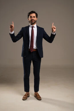 Gestures and expressions of joy and happiness, pointing with the index finger upwards, the concept of elegance and masculinity, a portrait of an Arab Gulf Saudi businessman wearing a formal suit, attention to external appearance, full-body, white background.