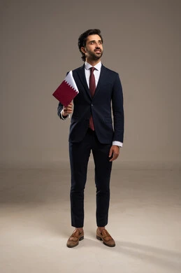 Love for the homeland and belonging to it, celebrating Qatar National Day on December 18, commemorating the founding of the state, a portrait of an Arab Gulf Qatari man wearing a formal suit holding the Qatari flag with gestures of pride and honor, national symbols and cultures, full-body, white background.