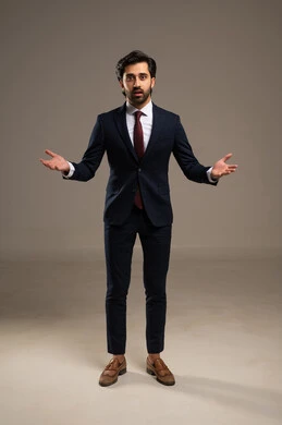 الاصابة بالصدمة والذهول، ايماءات وتعابير الحيرة وعدم المعرفة، بورتريه لرجل عربي خليجي سعودي يرتدي بدلة رسمية يضع يده على ذقنه، مفهوم الأناقة والرجولة والاهتمام بالمظهر الخارجي، الطول الكامل للجسم، خلفية بيضاء