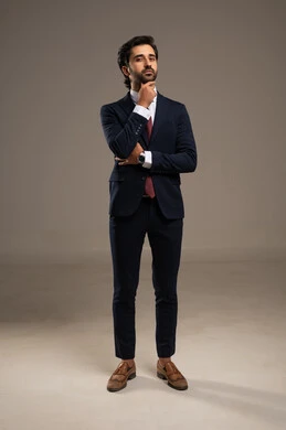 Gestures and expressions of thinking about something, a portrait of a Saudi Arabian Gulf man wearing a formal suit with his hand on his chin, the concept of elegance, masculinity, and attention to appearance, full body length, white background.