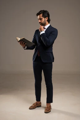 Gestures of distraction and thinking, learning and self-education, the concept of reading and literature, reading skills and increasing awareness, a portrait of a Saudi Gulf Arab businessman wearing a formal suit holding a book flipping through its pages to gain new experiences, full-body, white background. Gestures of distraction and thinking, learning and self-education, the concept of reading and literature, reading skills and increasing awareness, a portrait of a Saudi Gulf Arab businessman wearing a formal suit holding a book flipping through its pages to gain new experiences, full-body, white background.