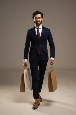 الاستفادة من مواسم الحسومات والتصفيات، التبضع وأخذ الاحتياجات اللازمة, المشتريات التجارية والهدايا, بورتريه لرجل عربي خليجي سعودي يرتدي الزي الرسمي و يمسك بيده أكياس ورقية، صورة الجسم بالكامل، خلفية بيضاء