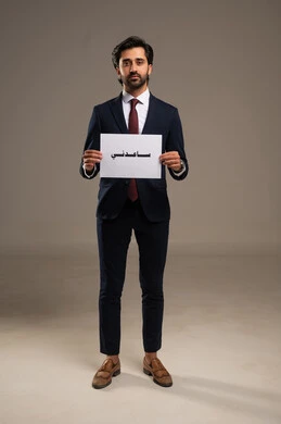 طلب المساعدة من احد ما، الشعور بالظلم وطلب العون، الاهتمام بالمظهر الخارجي والرجولة، بورتريه لرجل أعمال عربي خليجي سعودي يرتدي البدلة الرسمية يقف يحمل بيده لوحة بيضاء مكتوب عليها ساعدوني، خلفية بيضاء
