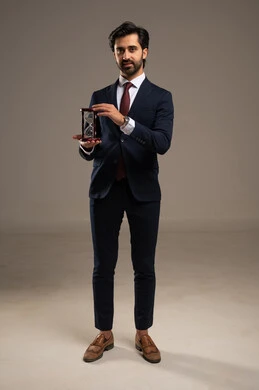 The concept of business management and organizing the schedule, realizing the value of precious moments, monitoring the sand timer, a portrait of an Arab Gulf Saudi man wearing a formal suit holding a glass hourglass (the bankam) in his hand, full-body, white background.