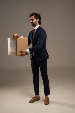 Humanitarian initiatives in the Kingdom of Saudi Arabia, attention to external appearance and self-confidence, a portrait of an Arab Gulf Saudi businessman wearing a formal suit standing holding a donation box, white background.