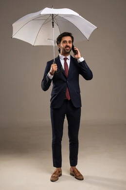 Making a phone call, winter atmosphere, the concept of protection from rain, using modern technologies, a portrait of an Arab Gulf Saudi businessman wearing a formal suit standing and holding an umbrella and a mobile phone, attention to external appearance, white background.