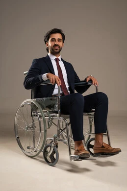 تأمين اجهزة ومعدات تساعد بالحركة والتنقل، العنايه بأصحاب الهمم وتأمين احتياجاتهم الخاصة، بورتريه لرجل مريض عربي سعودي خليجي من ذوي الاحتياجات الخاصه يجلس على كرسي متحرك، شعور المعاقين بالإنتماء والتقدير والإحترام في المملكة، خلفيه بيضاء