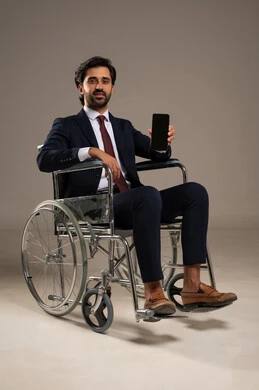 A blank black screen display, managing and organizing business affairs through technical devices, integrating work with technology and tech, a portrait of a Saudi Arabian Gulf man with special needs wearing formal attire sitting in a wheelchair holding a mobile phone, white background.