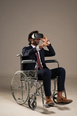 مفهوم التقنيات الإلكترونية الحديثة، دمج التكنولوجيا المتطورة فى الحياة اليومية ، قضاء أوقات ممتعة ومسلية بالألعاب الافتراضية،  بورتريه لرجل عربي خليجي سعودي يرتدي البدلة الرسمية يجلس على كرسي متحرك ويرتدي نظارة الواقع الافتراضي ثلاثية الابعاد، خلفية بيضاء