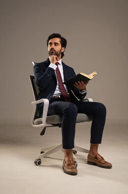 مفهوم التثقيف والبحث العلمي، قضاء الوقت بالقراءة والتعلم والثقافة، هواية المطالعة والاستكشاف، قضاء وقت الفراغ بالتعلم والثقافة، بورتريه لرجل عربي خليجي سعودي مبتسم يرتدي البدلة الرسمية يحمل بيده كتاب,  خلفية بيضاء
