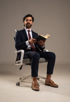 قضاء الوقت بالقراءة والتعلم والثقافة، مفهوم التثقيف والبحث العلمي، هواية المطالعة والاستكشاف، قضاء وقت الفراغ بالتعلم والثقافة، بورتريه لرجل عربي خليجي سعودي مبتسم يرتدي البدلة الرسمية يحمل بيده كتاب,  خلفية بيضاء