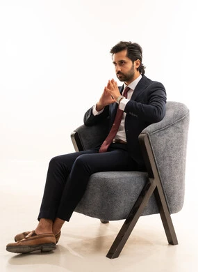 Expressions of boredom from waiting and loss of hope, interaction and engagement with the matches, a Saudi man cheering for the national team, a portrait of a young Arab Gulf Saudi man wearing the official outfit and sitting on a comfortable sofa with gestures of fear of goals being scored, the concept of beauty, elegance, and masculinity, white background.