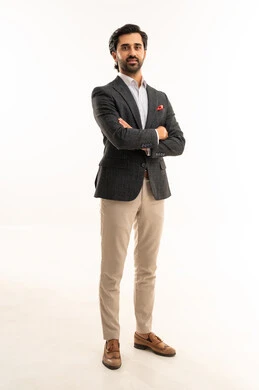 الوقوف بأيدي متقاطعة والنظر إلى الكاميرا بايماءات السرور والسعادة، مفهوم الاناقة والرجولة, بورتريه لرجل أعمال عربي خليجي سعودي يرتدي البدلة الرسمية, الاهتمام بالمظهر الخارجي، الجسم بالطول الكامل، خلفية بيضاء