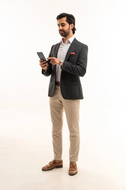 دمج التكنولوجيا في الحياة العملية، استخدام تقنية حديثة ومتطورة، إدارة شؤون العمل وتنظيمها عبر الإنترنت، بورتريه لرجل اعمال عربي خليجي سعودي يرتدي البدلة الرسمية يحمل بيده التابليت المحمول, الجسم بالطول الكامل، خلفية بيضاء
