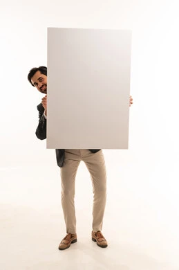 موك اب مستطيل ابيض، حملات اعلانية وتسويق، رفع اصبع السبابة والاشارة للوحة، مفهوم الاناقة والرجولة والاهتمام بالمظهر الخارجي، بورتريه لشاب عربي خليجي سعودي يرتدي البدلة الرسمية يحمل لوحة مستطيلة بيضاء, الجسم بالطول الكامل، خلفية بيضاء