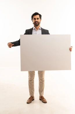 حملات اعلانية وتسويق، رفع اصبع السبابة والاشارة للوحة، موك اب مستطيل ابيض،  مفهوم الاناقة والرجولة والاهتمام بالمظهر الخارجي، بورتريه لشاب عربي خليجي سعودي يرتدي البدلة الرسمية يحمل لوحة كبيرة مستطيلة بيضاء, الجسم بالطول الكامل، خلفية بيضاء