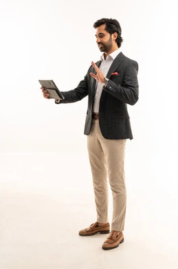 استخدام تقنية حديثة ومتطورة، إدارة شؤون الأعمال وتنظيمها، عقد إجتماع عمل عبر الإنترنت، بورتريه لرجل اعمال عربي خليجي سعودي يرتدي البدلة الرسمية يحمل بيده التابليت المحمول, دمج التكنولوجيا في الحياة العملية، الجسم بالطول الكامل، خلفية بيضاء