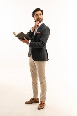 تعابير التفكير والشرود، التعلم والتثقيف الذاتي، مفهوم المطالعة والقراءة ، مهارة القراءة وزيادة الوعي، أنشطة شبابية ترفيهية، بورتريه لرجل أعمال عربي خليجي سعودي يرتدي البدلة الرسمية يحمل كتاب يقلب بين صفحاته لاكتساب خبرات جديدة, الجسم بالطول الكامل، خلفية بيضاء