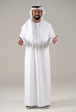 مفهوم السلام والتحية, ايماءات السرور والسعادة, تعابير الوجه ولغة الجسد المختلفة, بورتريه لرجل عربي خليجي اماراتي يرتدي الكندورة والغترة يرفع يديه بتعابير الترحيب, خلفية رمادية