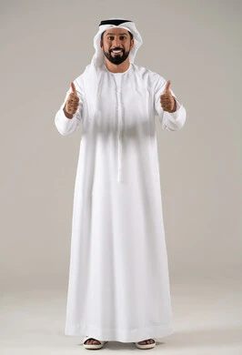 بورتريه لشاب عربي خليجي إماراتي يرتدي الكندورة والغترة يرفع ابهامه بإيماءات الجودة والامتياز والتميز، التعبير عن الجودة والاتقان، الموافقة والرضا و القبول، الوقوف بسرور وبشاشة وسعادة، خلفية رمادية