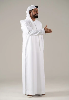 The concept of peace and welcome, gestures of joy and happiness, facial expressions and different body language, a side portrait of an Emirati Gulf Arab man wearing a kandura and ghutrah extending his right hand to greet, gray background.